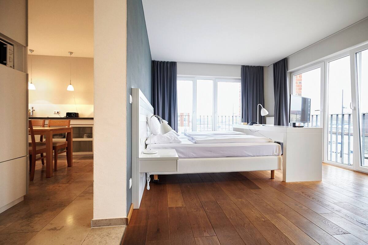 Ein modernes Hotelzimmer mit Bett, Schreibtisch und Blick auf die Stadt.