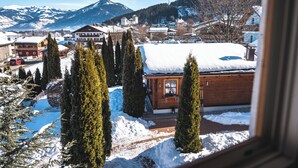 A snowy mountain town with a prominent tower, wooden buildings, and snow-covered paths. - Dorfchalets Kaprun (Kaprun)