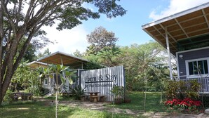 A property named 'Farm & Stay' with a covered outdoor seating area, a small garden, and a building with a sloped roof. - Sonseesaed Farm (Phu Ruea)