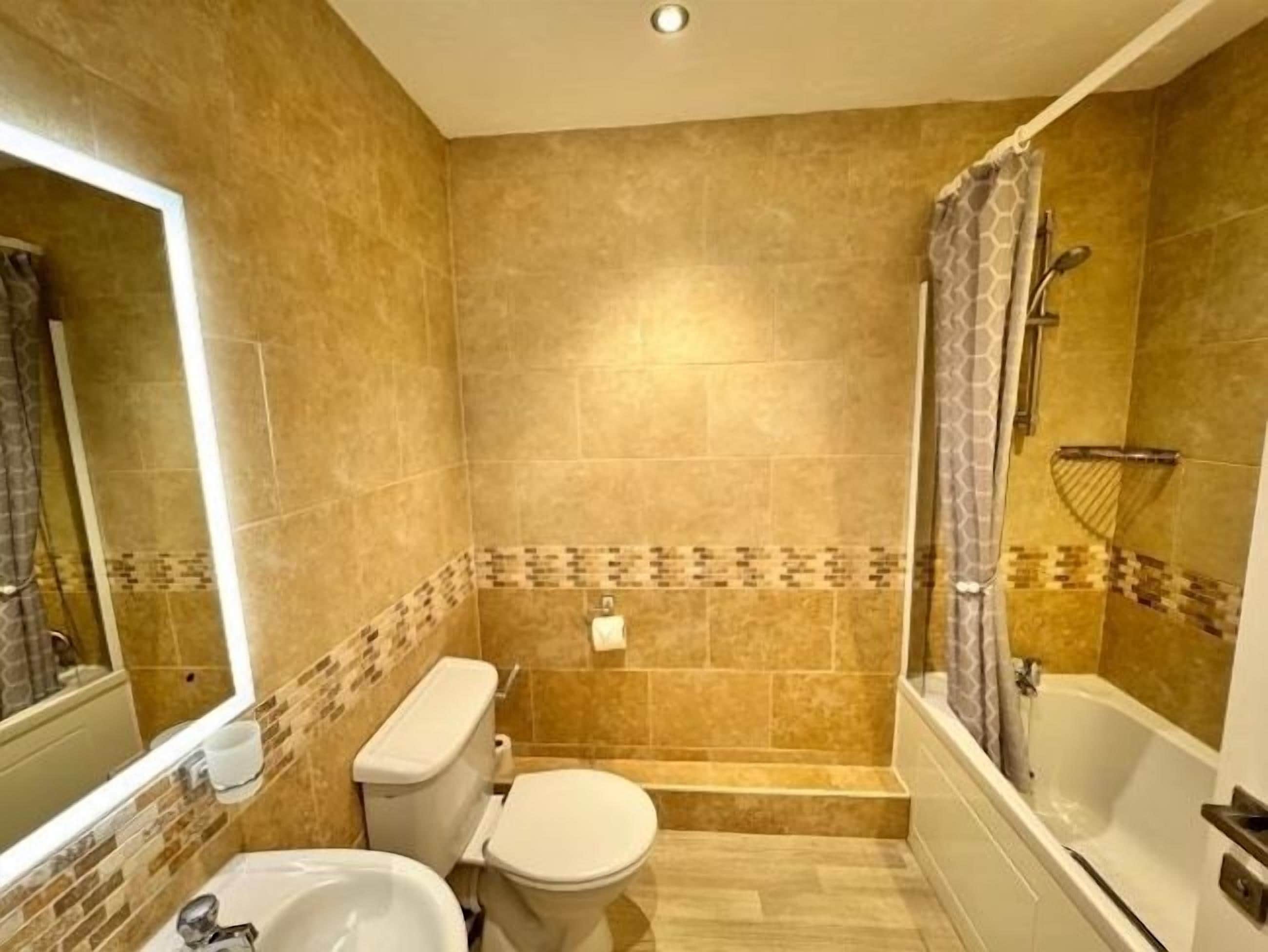 A bathroom with a toilet, sink, and bathtub.