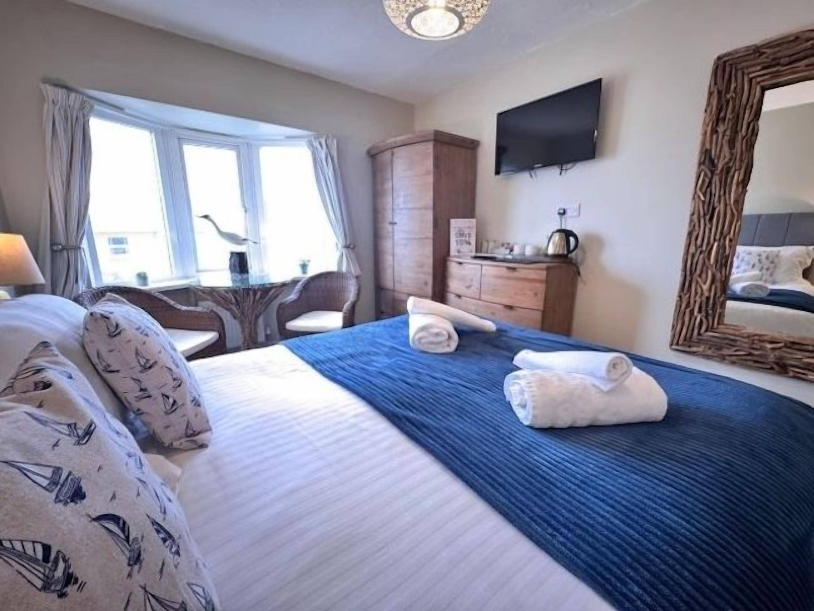 Une chambre d’hôtel équipée d’un lit, d’un bureau, d’une chaise, d’une armoire et d’un téléviseur.