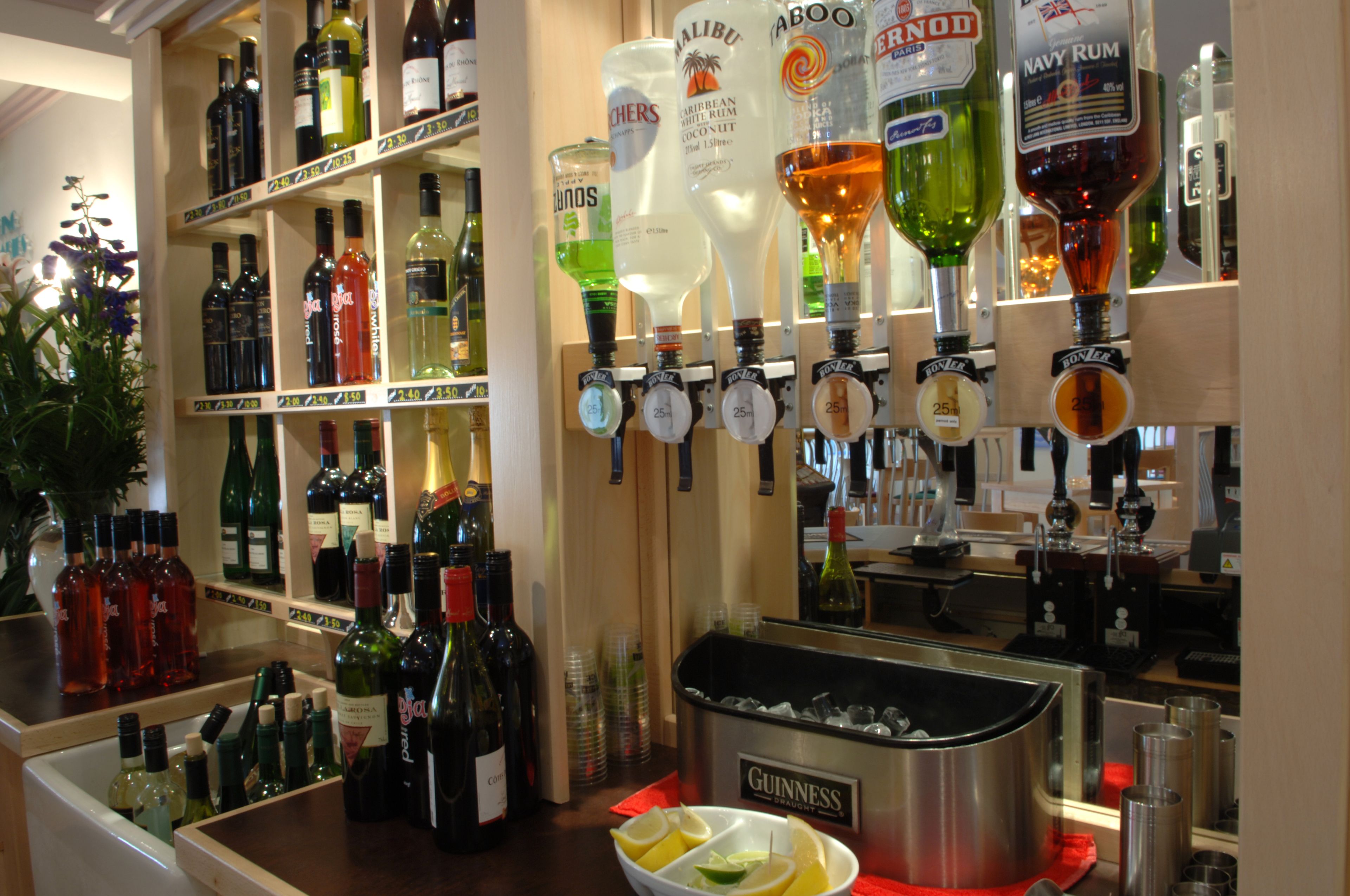 A bar area with various liquor bottles and a minibar with a Guinness beer tap.
