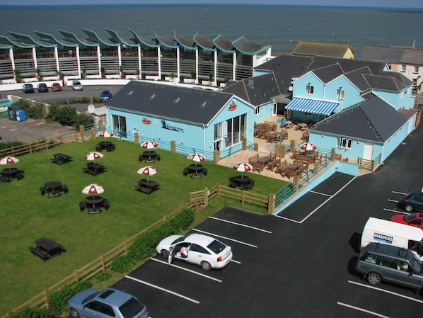 A seaside building with outdoor seating and a parking area. - The Waterfront Inn (Bideford)