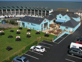 Un edificio frente al mar con terraza y zona de estacionamiento.