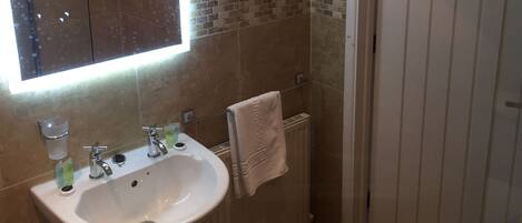 A bathroom with a sink, mirror, and towel rack.