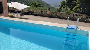 A swimming pool with a clear view of the surrounding area, including outdoor seating and a railing. - Locanda degli Ulivi (Arcugnano)