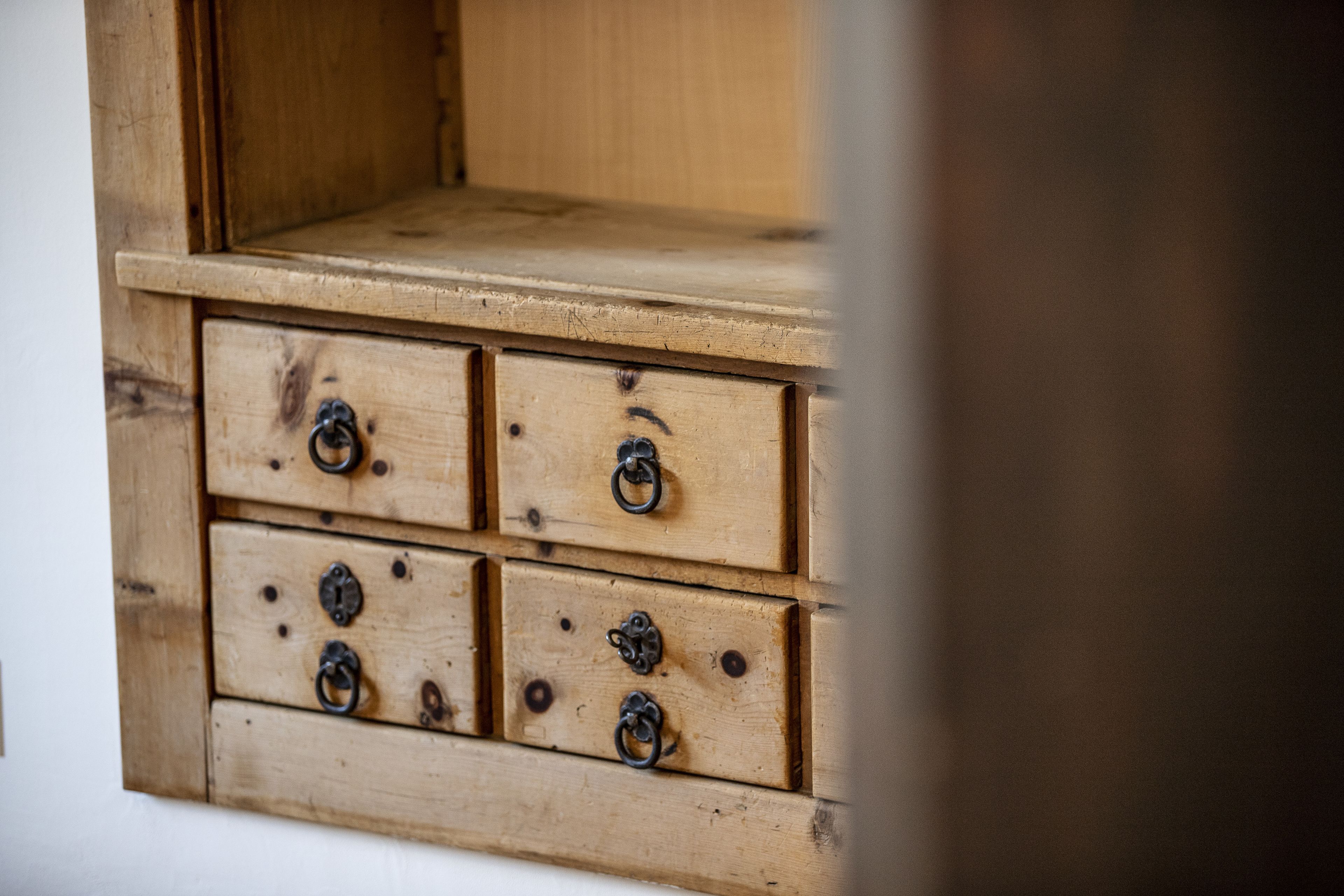 Une commode en bois avec quatre tiroirs et des poignées en métal.