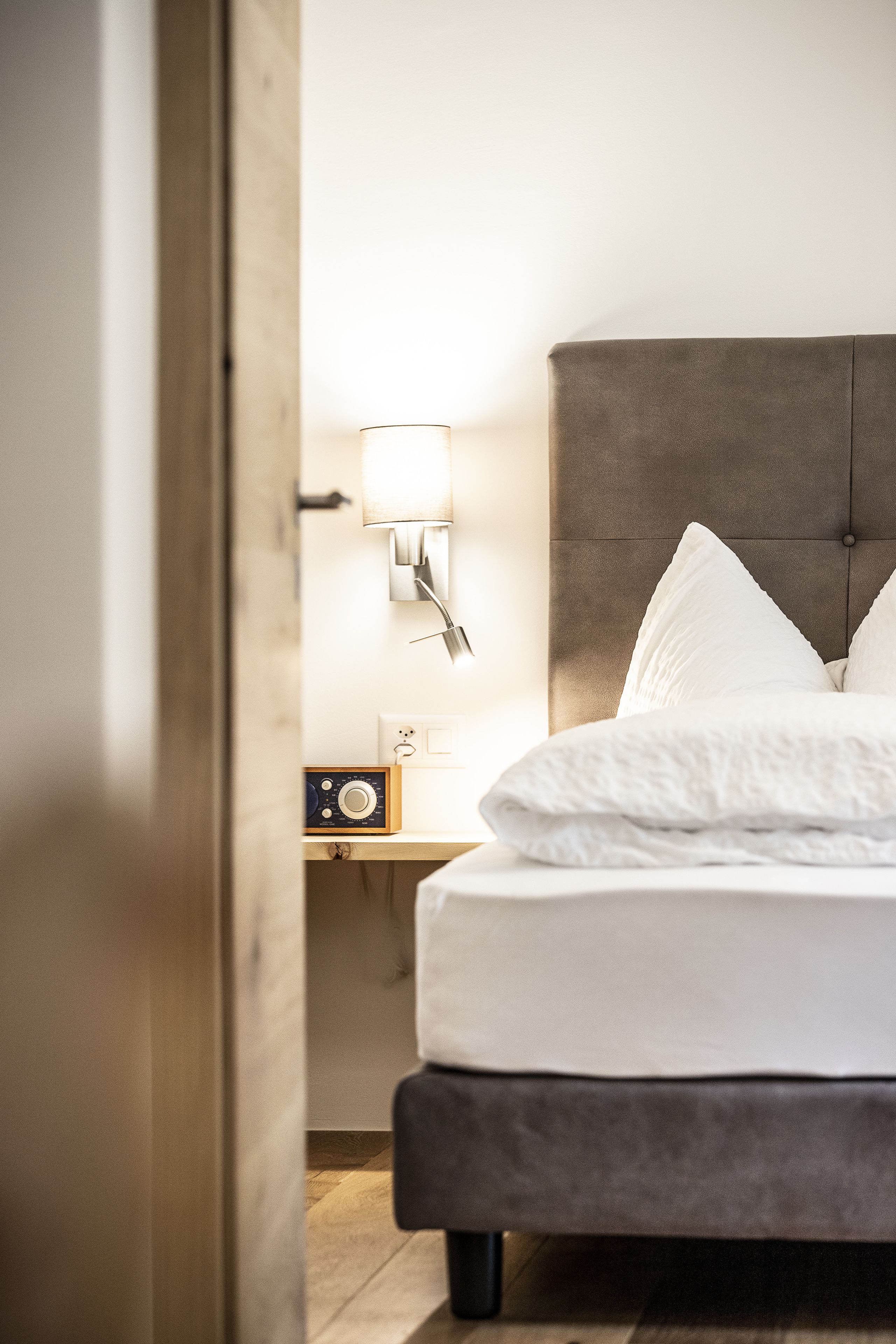 Ein Schlafzimmer mit einem Bett, einem Nachttisch, einer Lampe und einem Radio.