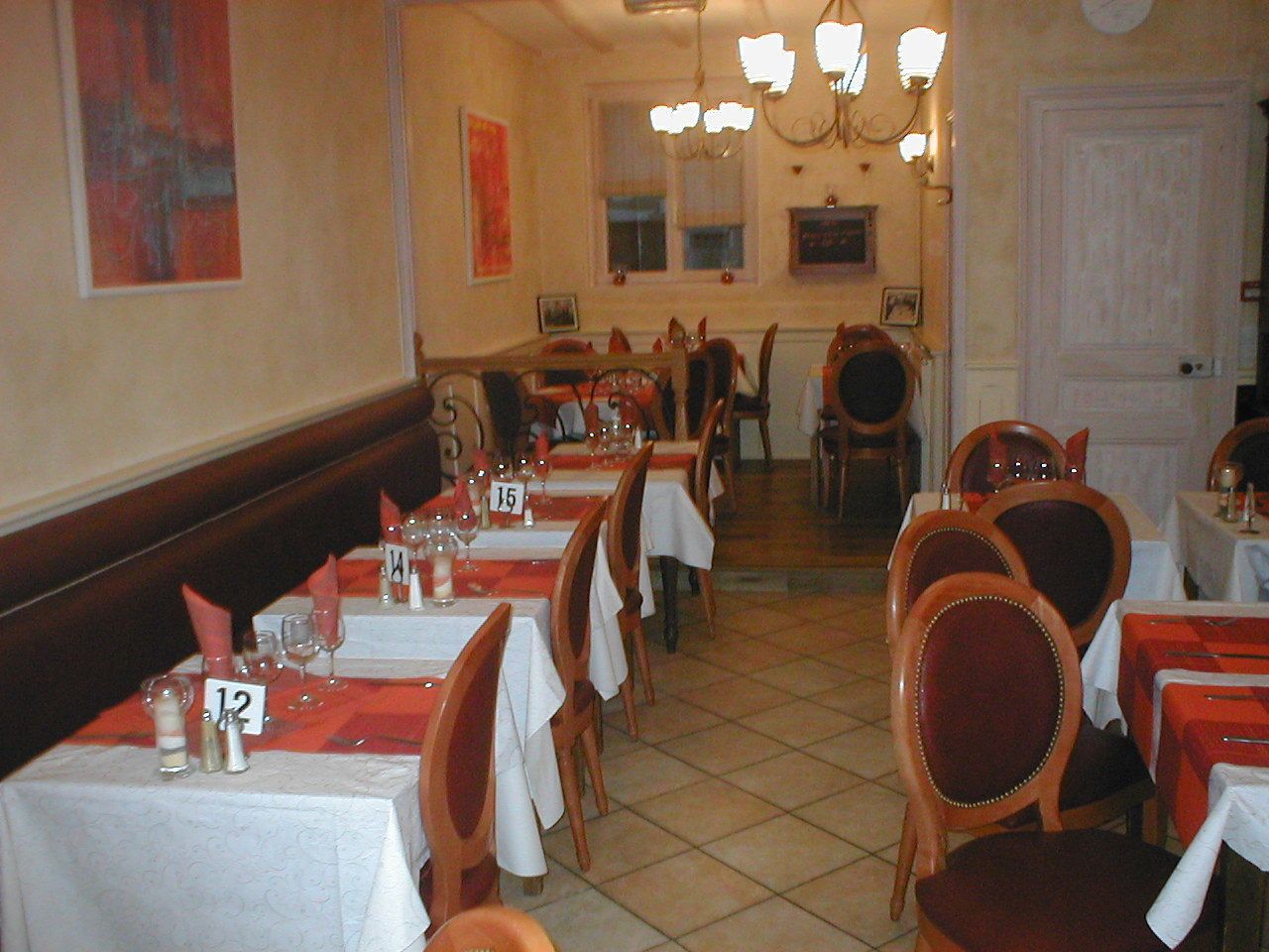 Ein Restaurant mit gedeckten Tischen, nummerierten Platzdeckchen und Stühlen.