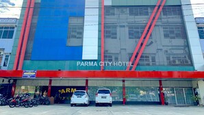 Un edificio moderno con fachada azul y roja, que dice 'PARMA CITY HOTEL'.