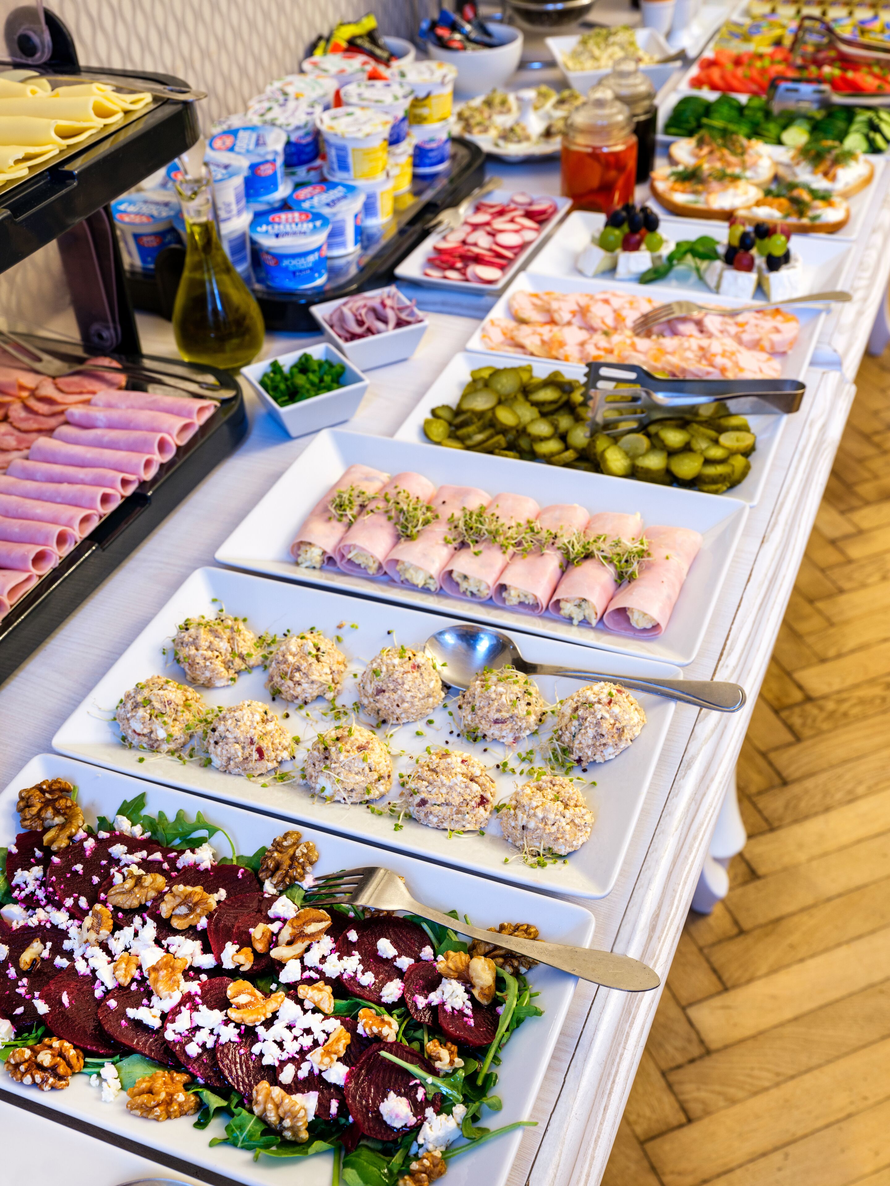A buffet with various food options including meats, cheeses, and salads.