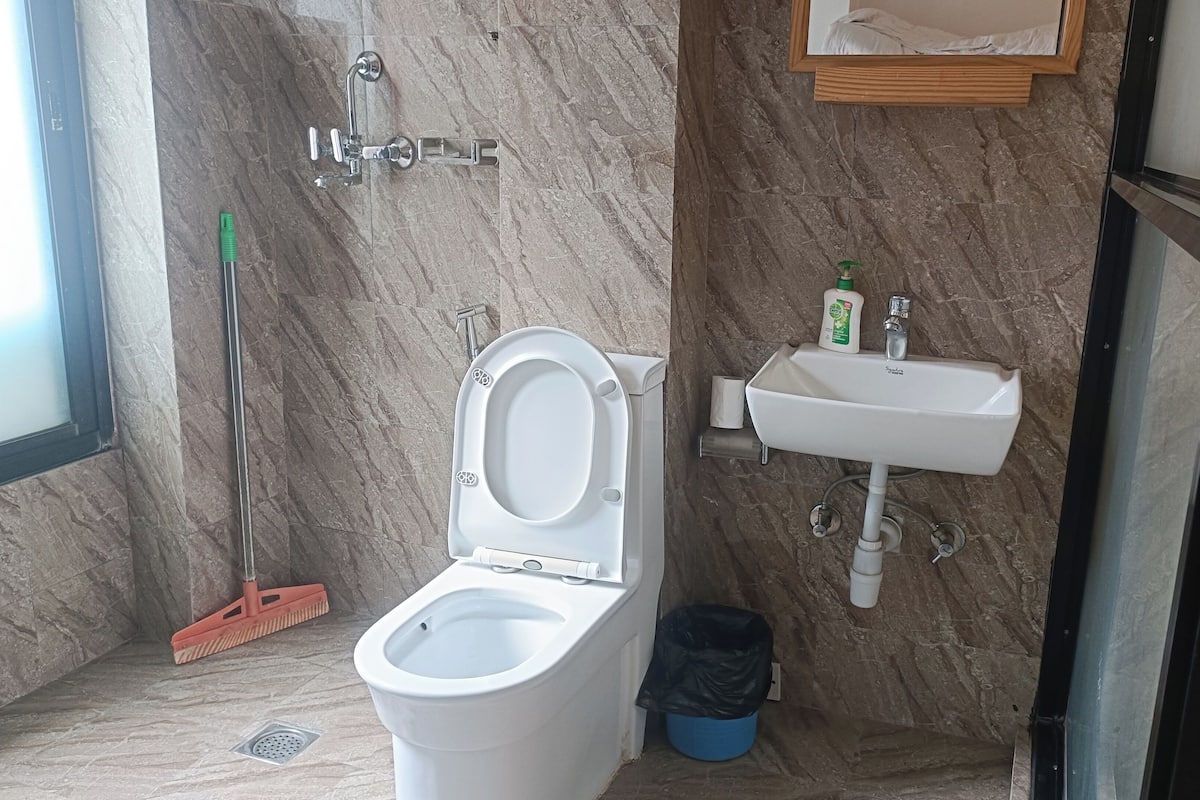 Un baño con inodoro, lavamanos y ducha.