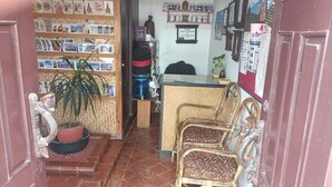 A small shop with shelves of postcards, a reception desk, wicker furniture, and a potted plant. - Easy Homes (Lalitpur)