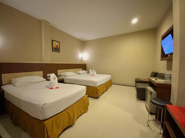 A hotel room with two beds, a TV, a desk, and a trash bin.