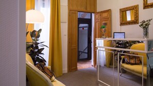 Habitación de hotel con escritorio, silla y vista al exterior.