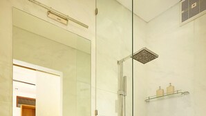 A modern bathroom with a glass-enclosed shower, a large mirror, and a wooden vanity with a bowl sink. - The Hotman Paris II Seminyak (Seminyak)
