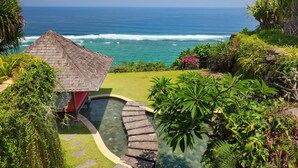A tropical resort with a thatched-roof hut, a swimming pool, and a view of the ocean. - The Cliff Hotman Paris VI Pandawa (Kutuh)