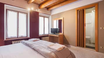 Cortinas blackout, tabla de planchar con plancha y ropa de cama