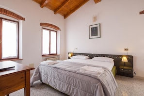 Cortinas opacas, tabla de planchar con plancha, ropa de cama
