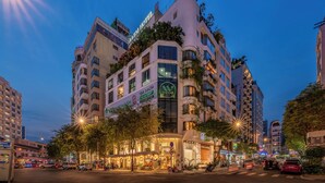 A multi-story hotel with a unique architectural design, featuring balconies and a prominent sign for a hotel named "A & E Hotel". - A&EM Art Hotel (Ho Chi Minh City)