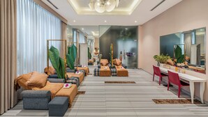A modern hotel room with a large bed, a sitting area with sofas and chairs, a dining table, and a large mirror. - A&EM Art Hotel (Ho Chi Minh City)