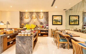 A modern dining area with marble countertops, wooden furniture, and pendant lighting. - A&EM Art Hotel (Ho Chi Minh City)