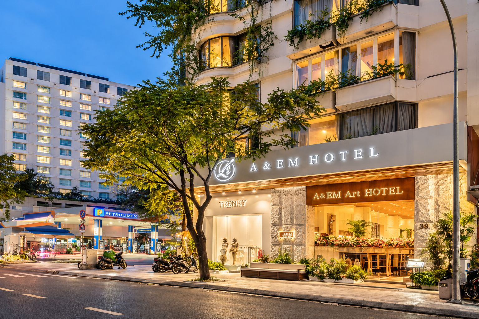 Hotel com fachada moderna, entrada imponente e área de estacionamento visível.