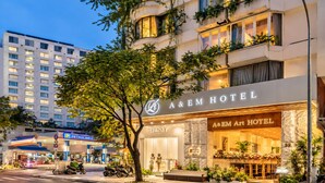 Hotel com fachada moderna, entrada imponente e área de estacionamento visível.