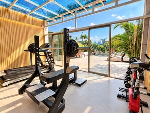 A gym with a treadmill, weight bench, and various exercise equipment. - A&EM Art Hotel (Ho Chi Minh City)