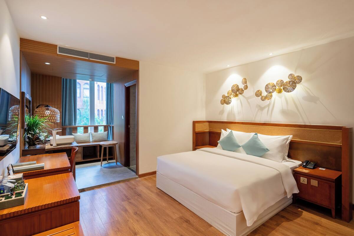 Une chambre d’hôtel moderne avec un grand lit, un bureau et une télévision.