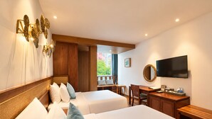 Une chambre d’hôtel avec deux lits, un bureau, une chaise, une télévision et une fenêtre donnant sur un paysage agréable.