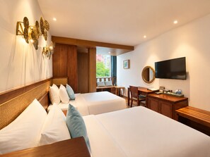 Une chambre d’hôtel avec deux lits, un bureau, une chaise, une télévision et une fenêtre donnant sur un paysage agréable.