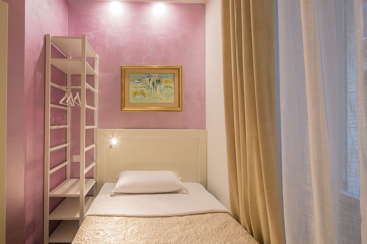 Ein Schlafzimmer mit Etagenbett, einem Bild an der Wand und einem Fenster mit Vorhängen.