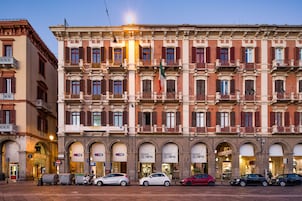 Un edificio a più piani con negozi al piano terra, tra cui un negozio TIM.