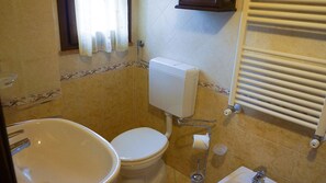 A small bathroom with a toilet, sink, and towel rack. - Agriturismo Cameli (Certaldo)