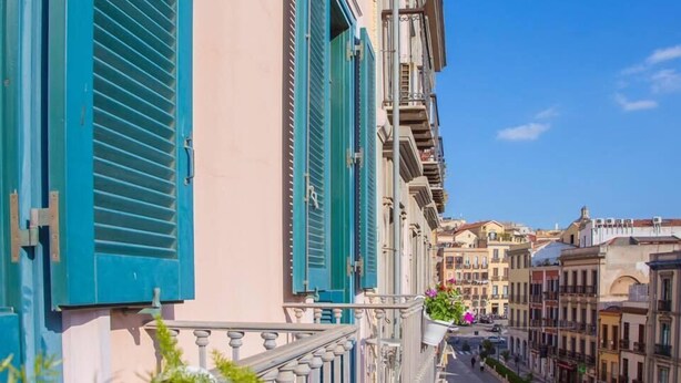 Ein Gebäude mit blauen Fensterläden und einem Balkon mit Geländer.