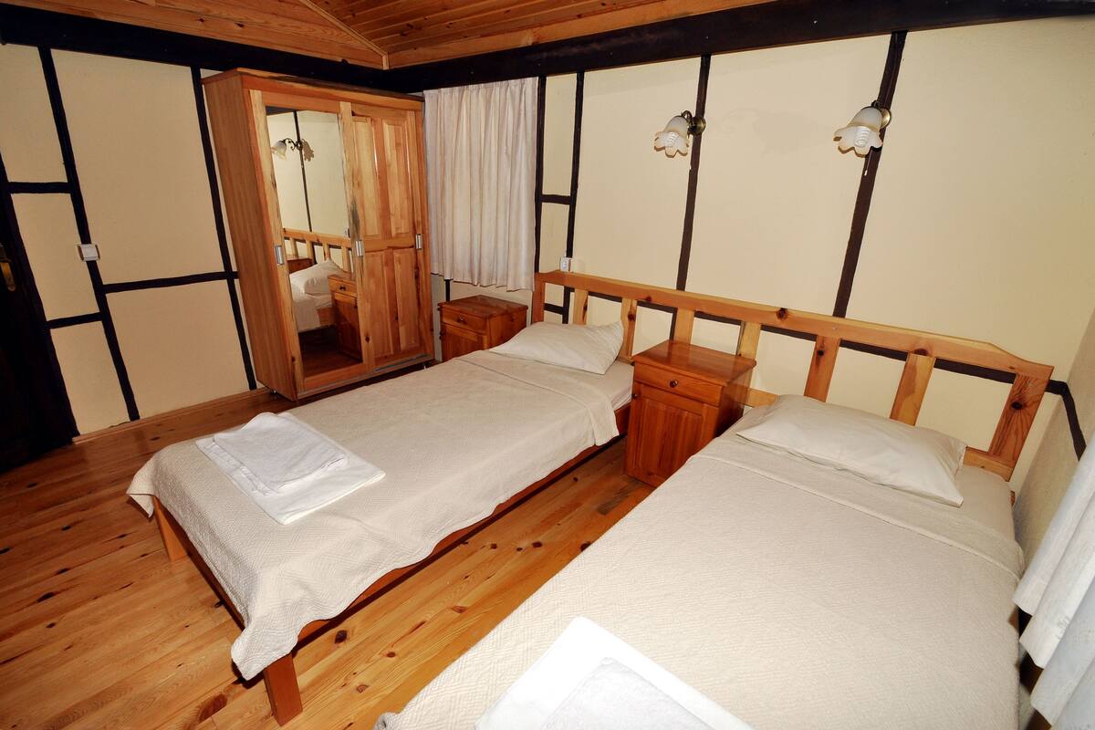 Une pièce de style japonais traditionnel, avec deux lits en bois, une armoire en bois et un miroir.