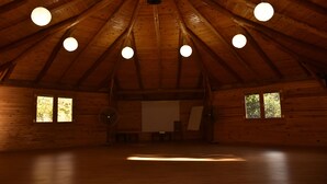 A spacious room with a high wooden ceiling and multiple hanging spherical lights.
