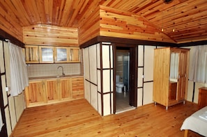 Un interior de madera con cocina, baño y dormitorio.