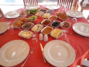 Una mesa dispuesta para una comida, con diferentes platos y condimentos.
