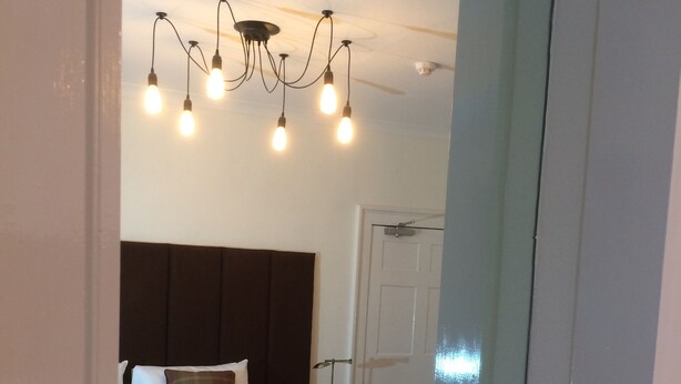 A bedroom with a bed, a nightstand, a mirror, and a ceiling fan. - Bongate House (Appleby-in-Westmorland)