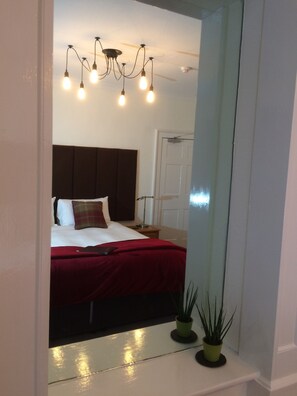 A bedroom with a bed, a nightstand, a mirror, and a ceiling fan. - Bongate House (Appleby-in-Westmorland)