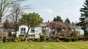 A two-story house with a front lawn and a small garden. - Bongate House (Appleby-in-Westmorland)