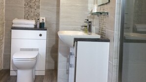 A modern bathroom with a toilet, sink, and shower. - Bongate House (Appleby-in-Westmorland)