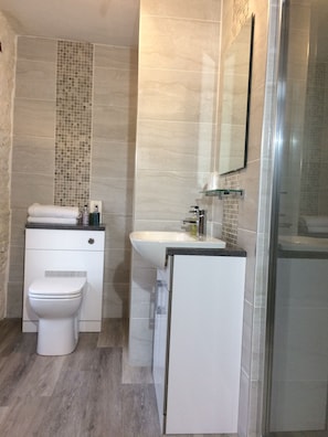 Ein modernes Badezimmer mit Toilette, Waschbecken und Dusche.