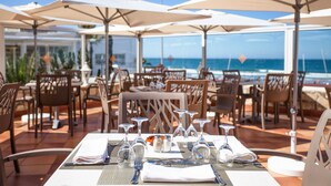 An outdoor dining area with tables set for two, featuring clear glassware and neatly folded napkins. - Dunes d'Or Ocean Club (Agadir)