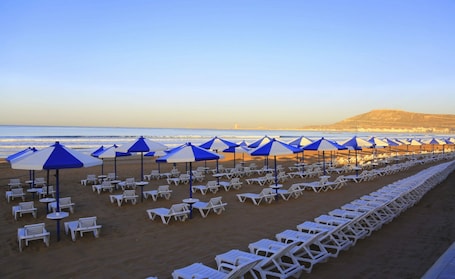 En la playa, sillas reclinables de playa, sombrillas