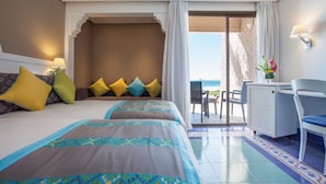 A hotel room with two beds, a desk, a chair, and a view of the ocean. - Dunes d'Or Ocean Club (Agadir)