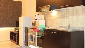 A compact kitchen with a washing machine, a microwave, and a toaster.
