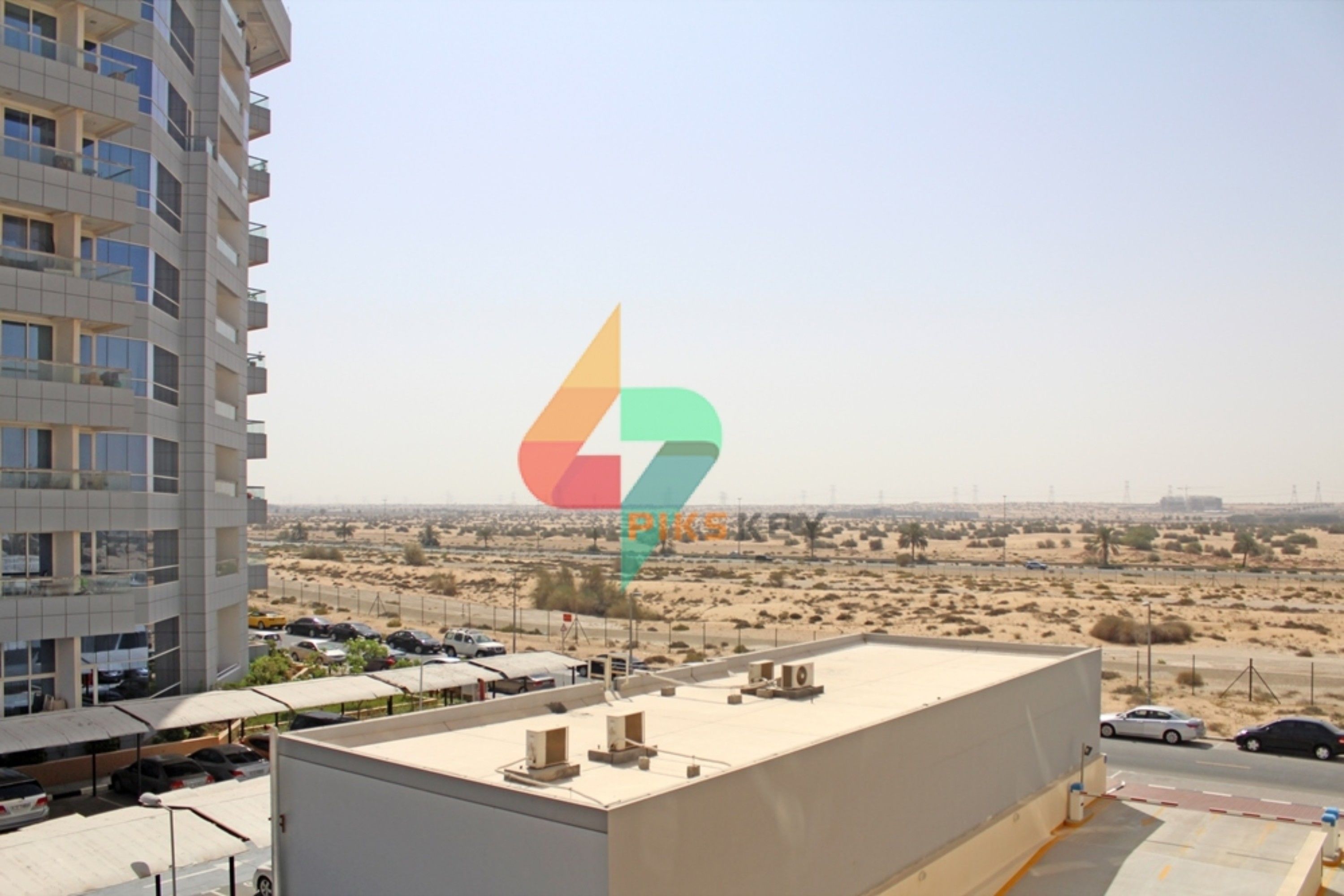 A modern building with a flat roof, surrounded by a desert landscape.